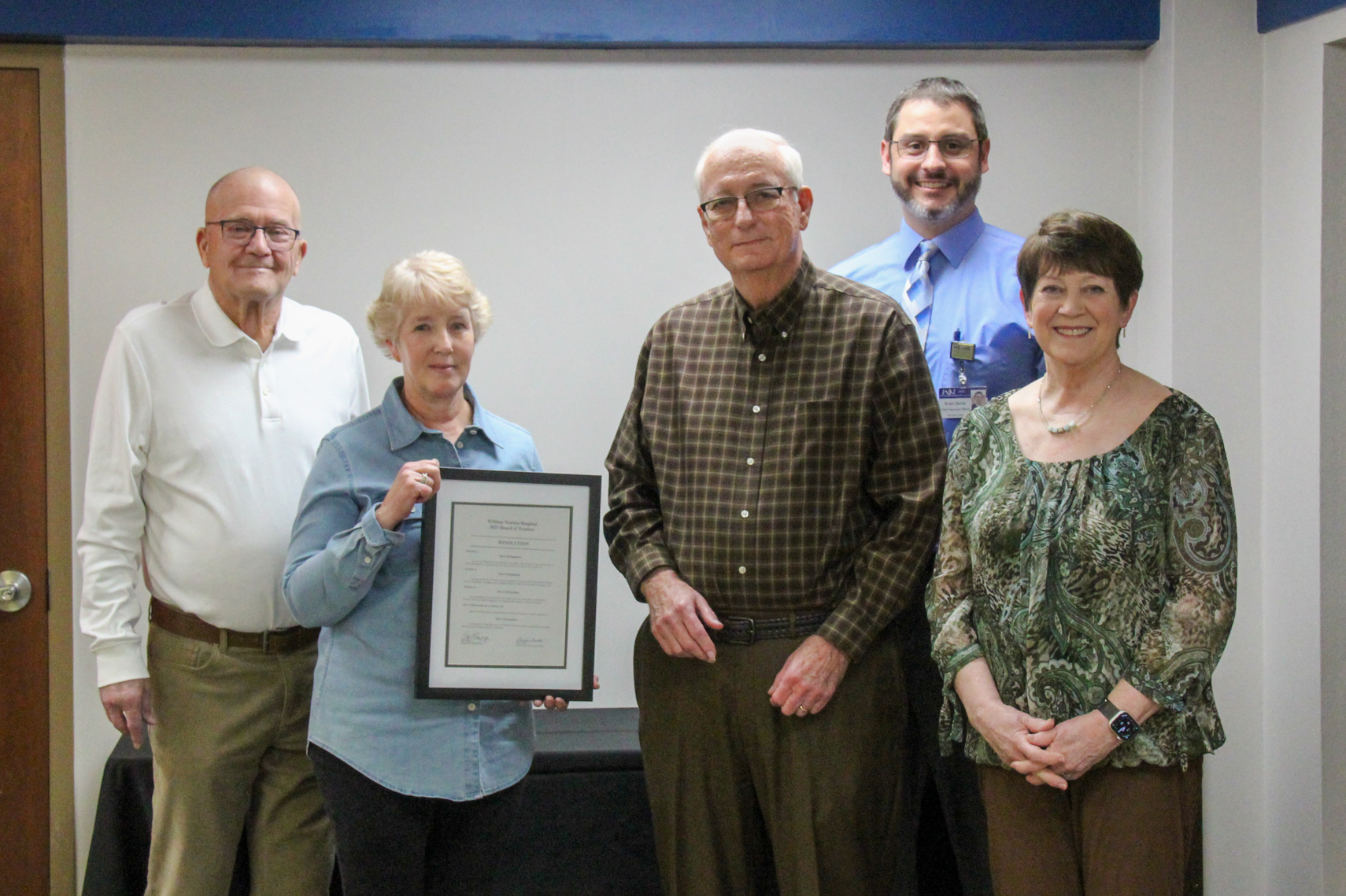 Steve McSpadden is presented with a framed resolution in recognition of his years of service as a William Newton Hospital trustee. From left: Dick Vaught, Gail Sawyer, Steve McSpadden, Brian Barta, and Marilyn McSpadden.