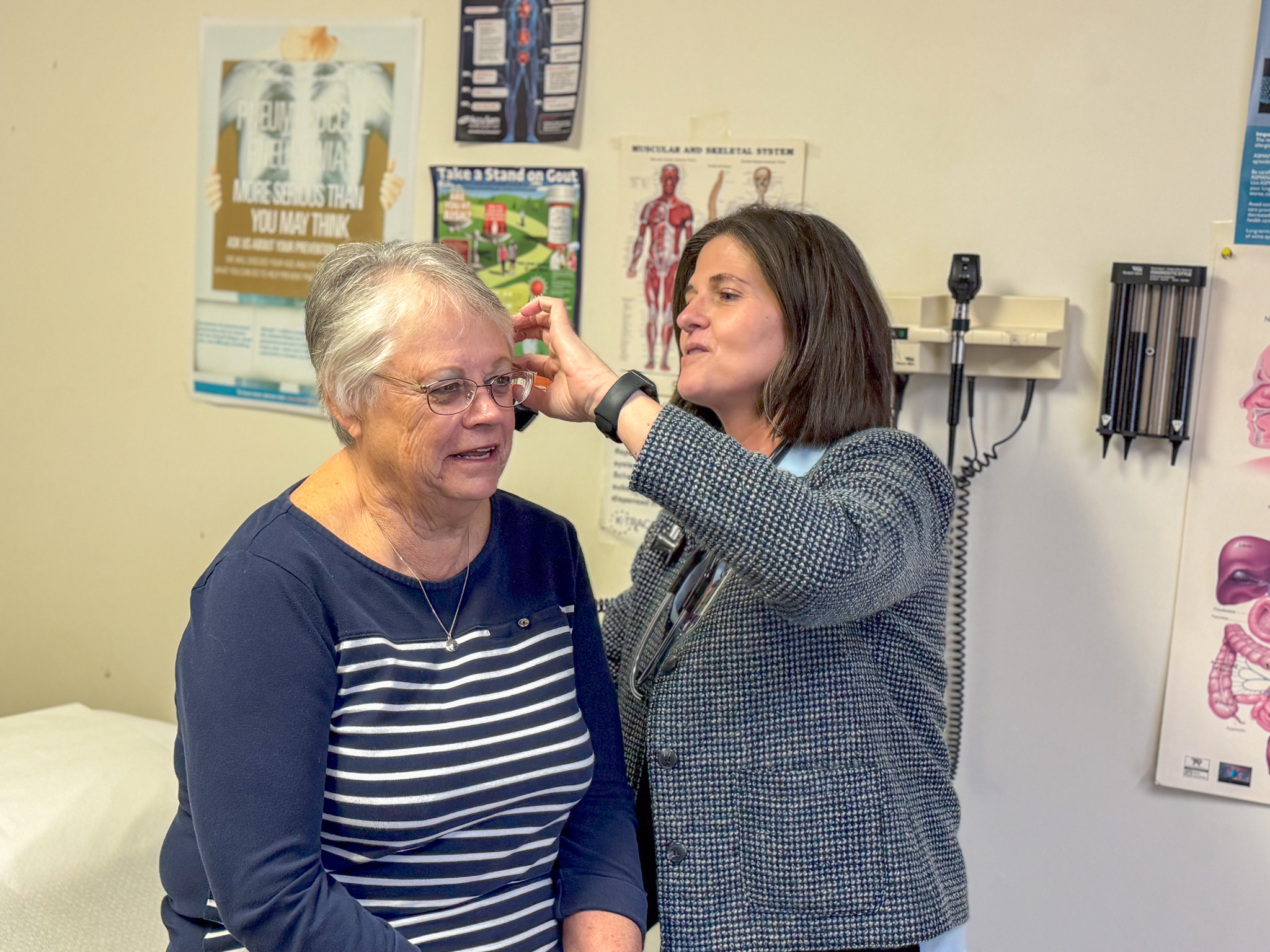 Moline provider Carey Hurt, APRN, peeks inside a patient's ear canal.